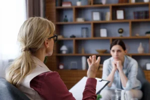 Shows a trauma therapist in Fort Worth, TX talking to a client in front of them about trauma. Represents how trauma therapy in Fort Worth, TX can help people with their trauma.