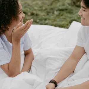 Shows a couple sitting on a blanket outside talking. Represents how your can thrive in relationships thanks to trauma counseling in Fort Worth, TX and a Fort Worth trauma therapist.